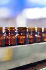 Farmaceutisch glaswerk op transportband naar vul- en sluitmachine